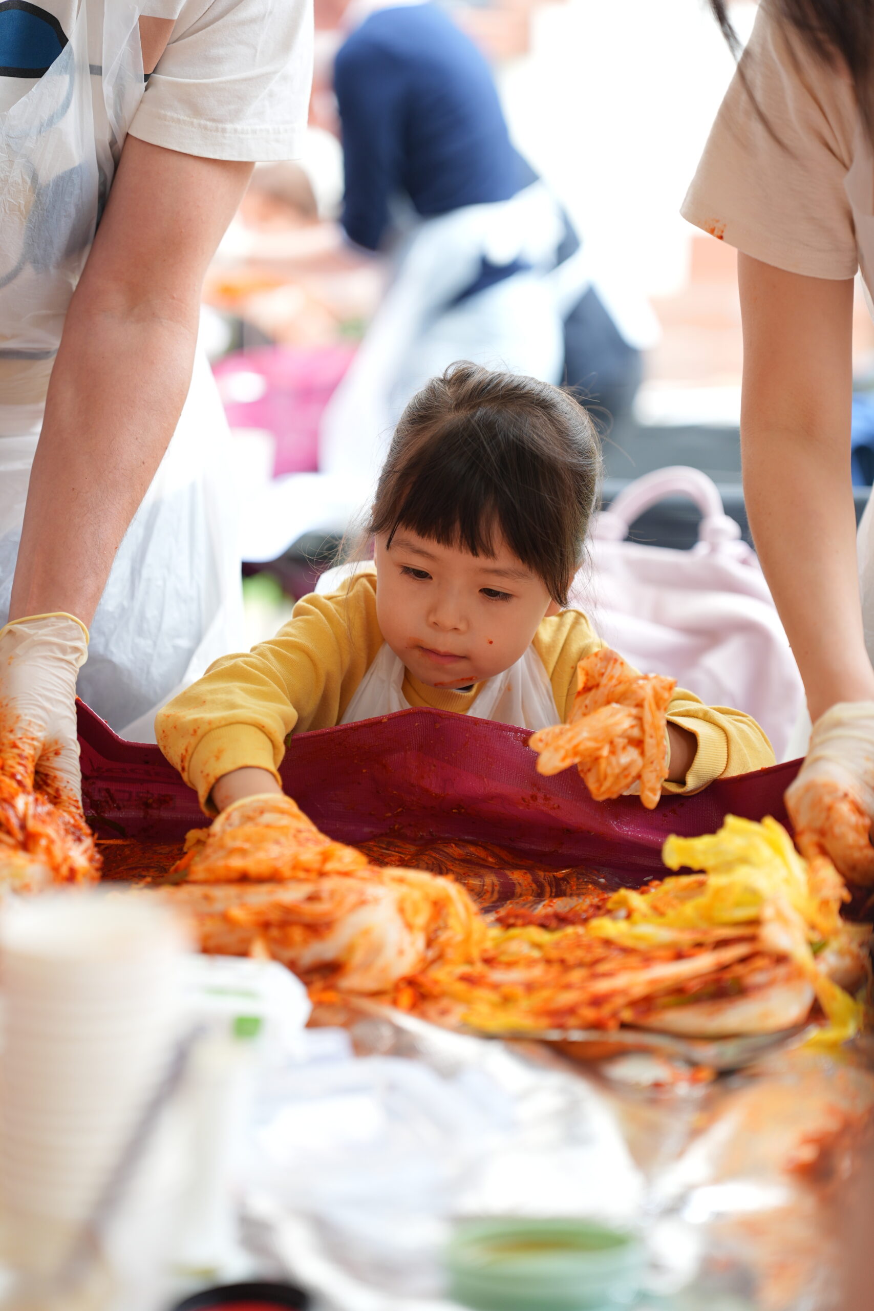 Tiny hands, big flavor — even the youngest kimchi maker got involved. Photo Credit: Charlie Hui / Friends of Korea