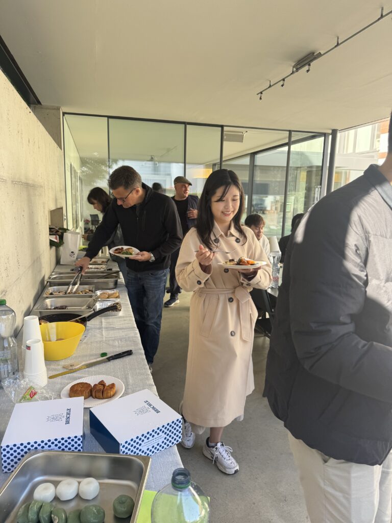 Community members serving food from diverse cultural dishes at Friends of Korea potluck buffet table