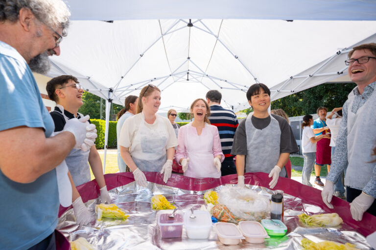everyone laughing around the kimchi table