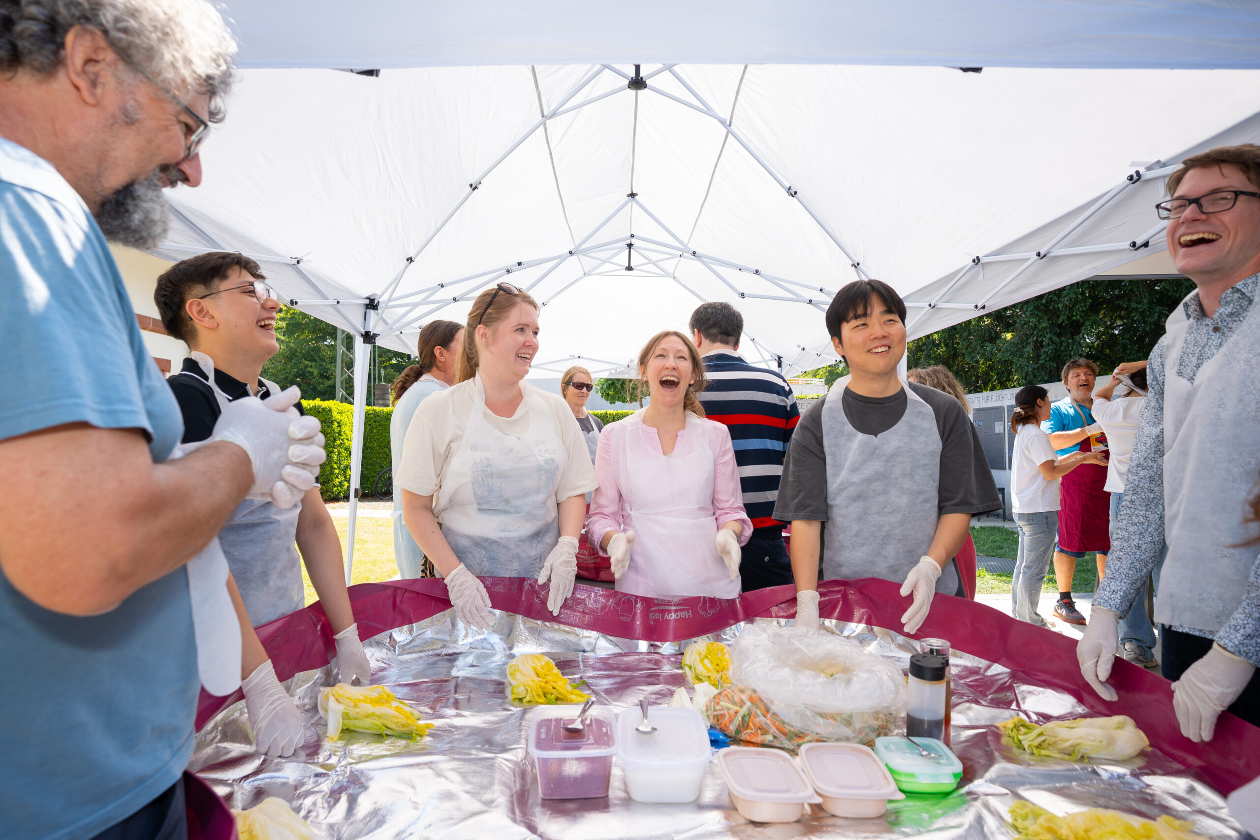 everyone laughing around the kimchi table